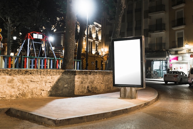 Unbelegte Bushaltestelle, die Anschlagtafel in der Stadt nachts annonciert