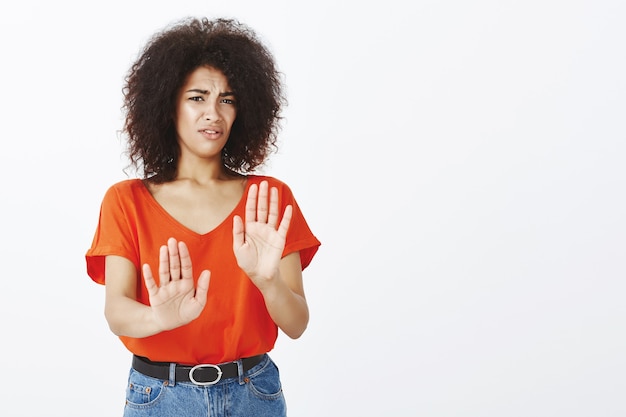 unbequeme Frau mit Afro-Frisur posiert im Studio