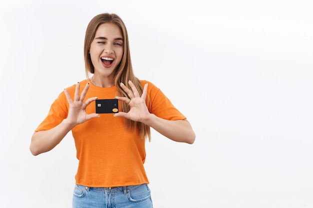 Unbeschwertes, glückliches blondes mädchen im orangefarbenen t-shirt