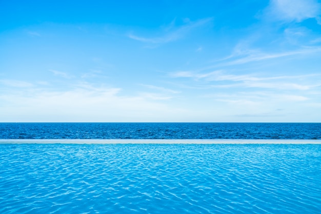 Unendlichkeitswimmingpool mit See- und Meerblick auf blauem Himmel