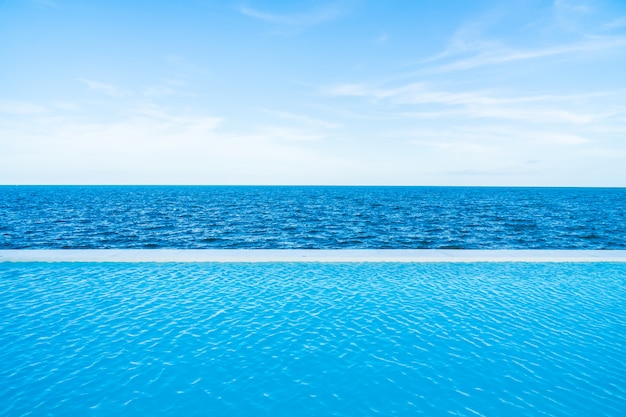 Kostenloses Foto unendlichkeitswimmingpool mit see- und meerblick auf blauem himmel