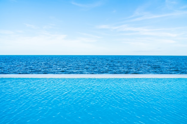 Unendlichkeitswimmingpool mit See- und Meerblick auf blauem Himmel