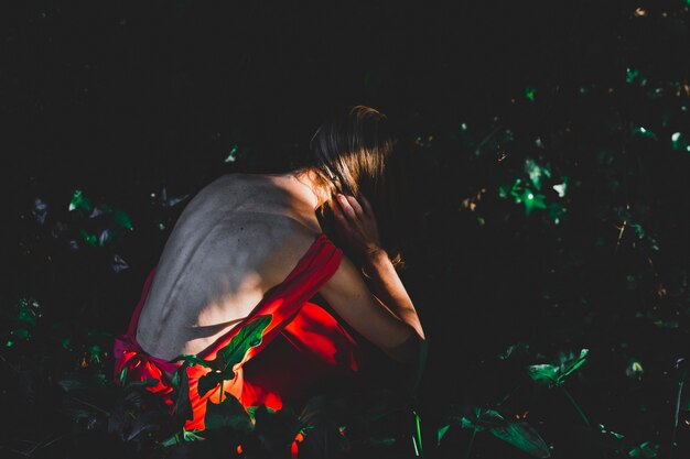 Unerkennbare Frau, die im Schatten sitzt