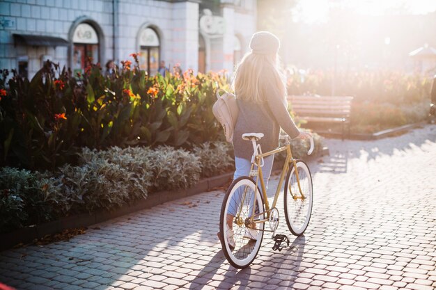 Unerkennbare Frau, die mit Fahrrad im Park geht