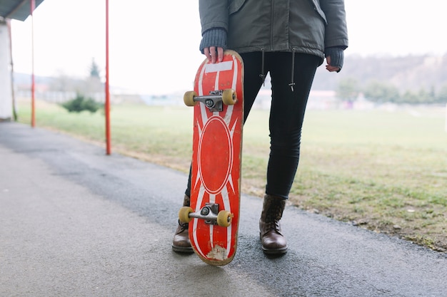 Unerkennbare Frau mit Skateboard