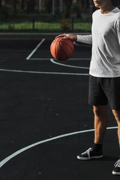 Unerkennbarer Athlet, der Basketball auf Gericht aufprallt