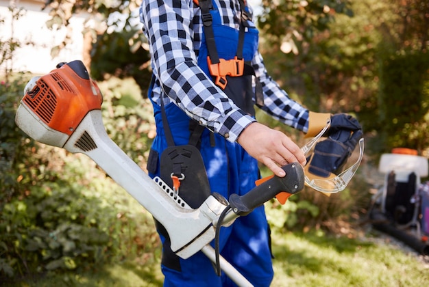 Unerkennbarer Gärtner mit modernem Weedwacker