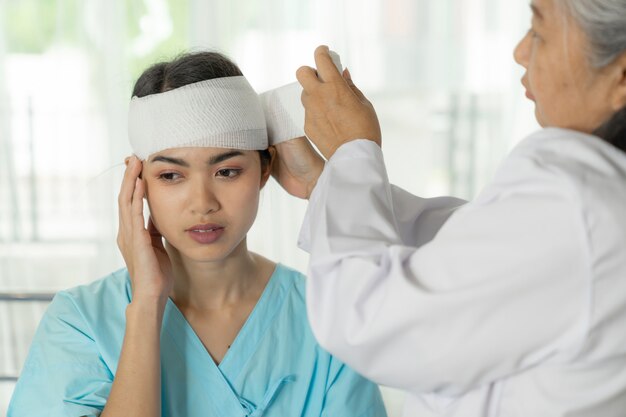 Unfallpatientenverletzung Kopfschmerzfrau im Krankenhaus - medizinisches Konzept