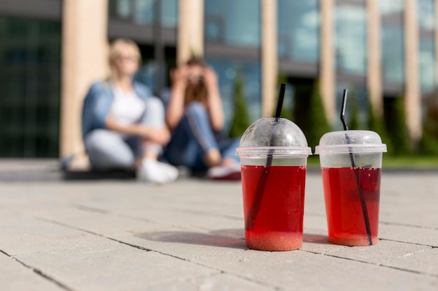 Kostenloses Foto unfokussierte freunde mit konzentriertem rotem saft