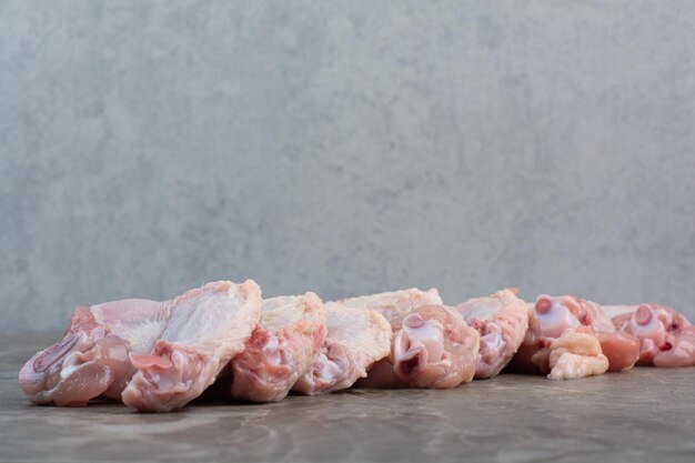 Ungekochte Hühnerbeine auf Marmorhintergrund. Foto in hoher Qualität