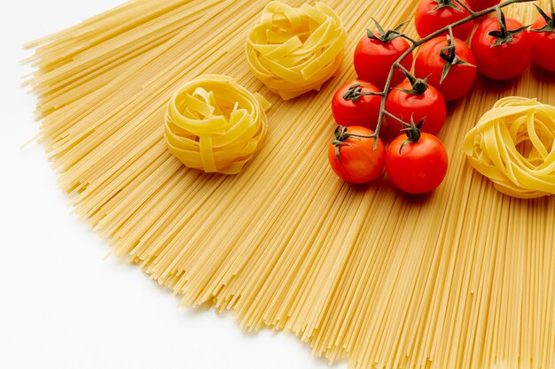 Ungekochte Spaghetti-Bandnudeln und Tomaten