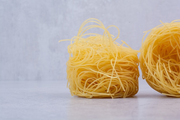 Ungekochte Spaghetti-Nester auf Steinoberfläche
