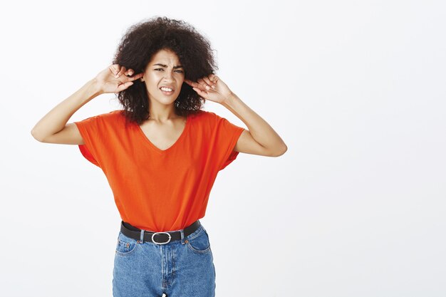 unglückliche Frau mit Afro-Frisur, die im Studio aufwirft