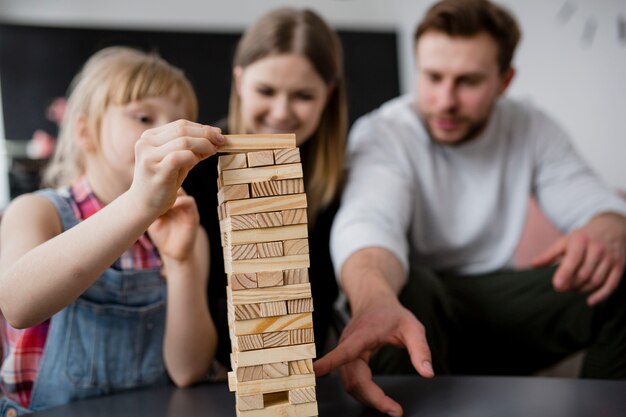 Unscharfe Familie, die jenga spielt