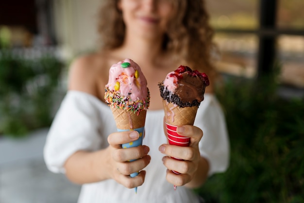 Unscharfe Frau der Vorderansicht, die Eiscreme hält