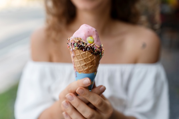 Unscharfe Frau der Vorderansicht, die Eiscreme hält