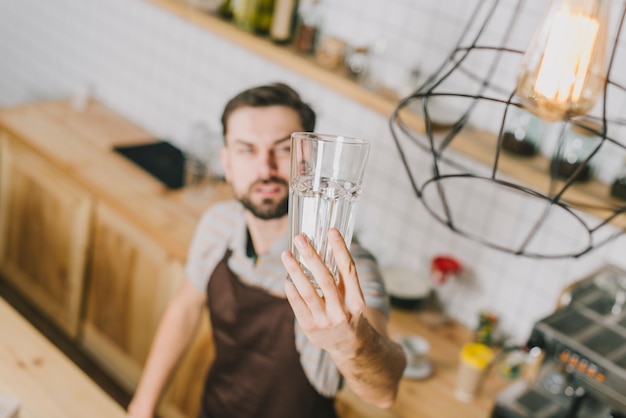 Unscharfer Mann, der Glas betrachtet