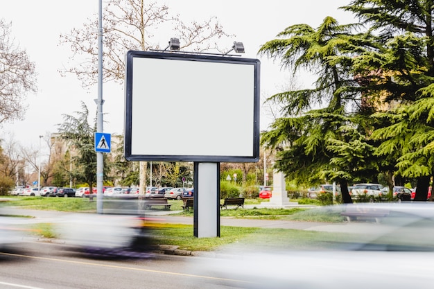 Unscharfes Fahrzeug, das durch die unbelegte Anschlagtafel auf der Straße überschreitet