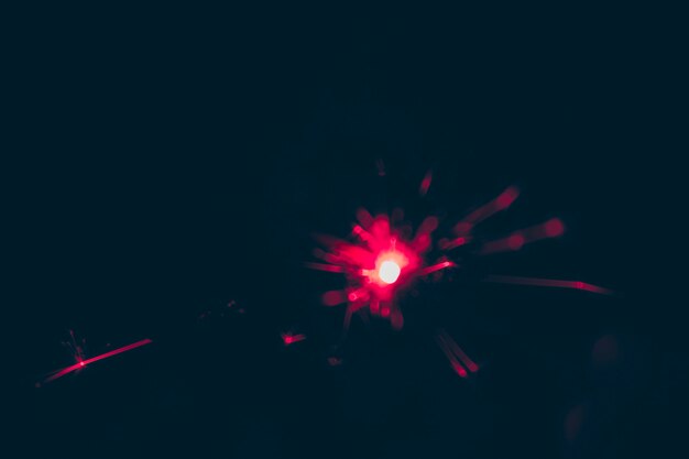 Unscharfes rotes Feuerwerk am Sylvesterabend auf schwarzem Hintergrund