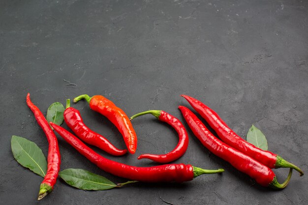 Unten Ansicht rote Paprika und Lohnblätter auf schwarzem Hintergrund