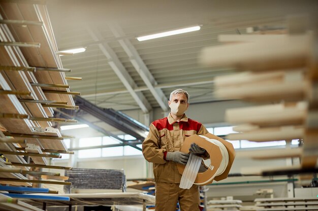 Unteransicht eines Tischlers, der Schutzschaum trägt, während er in einer Werkstatt arbeitet