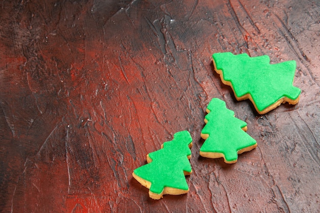 Kostenloses Foto unteransicht weihnachtsbaumkekse auf dunkelrotem tischfreiraum