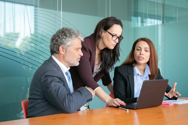 Unternehmensgruppe beobachtet Präsentation und diskutiert Projekt bei Besprechung