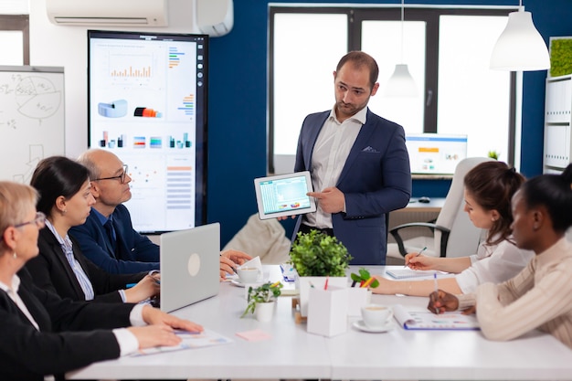 Unternehmensleitung erklärt dem Team das Briefing-Projekt im Konferenzraum