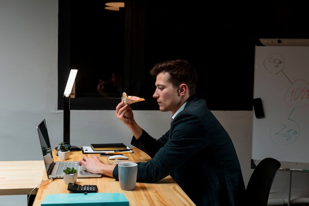 Unternehmer, der einen Snack während der Arbeit von zu Hause aus hat