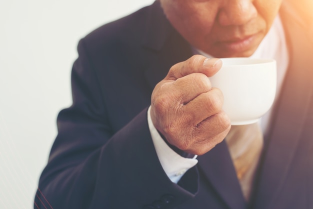 Kostenloses Foto unternehmer, die eine tasse kaffee auf weißem hintergrund isoliert