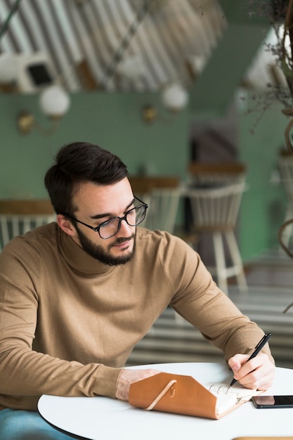 Kostenloses Foto unternehmer schreiben in agenda