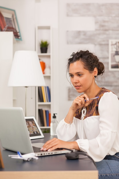 Kostenloses Foto unternehmerin, die laptop während der arbeit vom home office betrachtet.