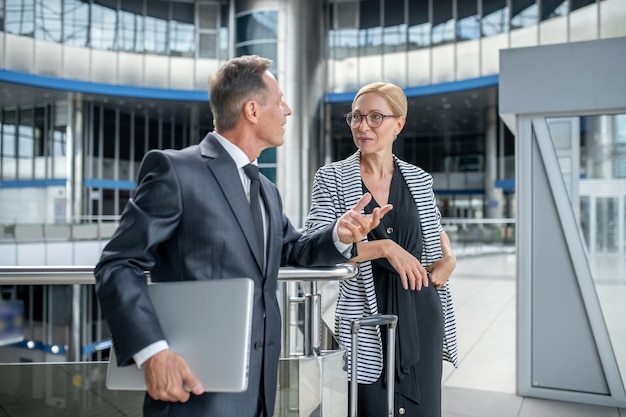 Unternehmerin kommuniziert mit ihrem Geschäftspartner am Flughafen