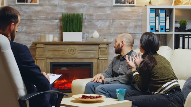 Unterschiedliche Frau bei der Beziehungsberatung mit ihrem Freund. Psychoanalyse macht Notizen.