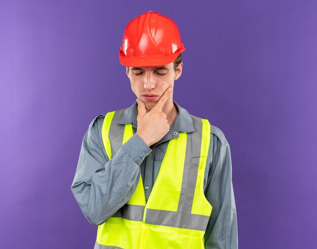 Unzufrieden mit geschlossenen Augen packte der junge Baumeister in Uniform das Kinn