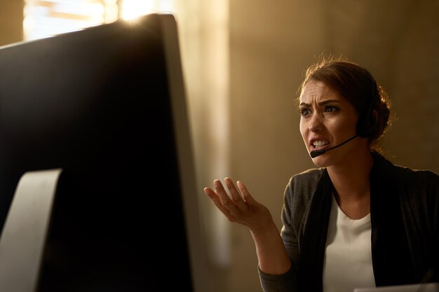 Unzufriedene Geschäftsfrau, die problematische E-Mails auf einem Computer im Büro liest