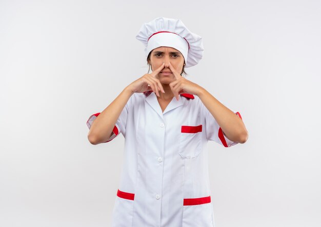 Unzufriedene junge Köchin, die die geschlossene Nase der Kochuniform mit Kopierraum trägt