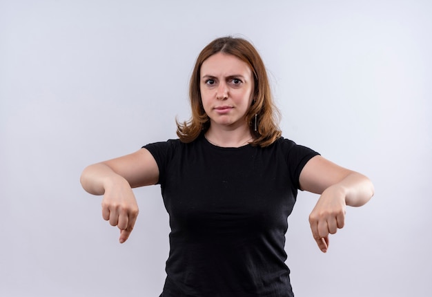 Kostenloses Foto unzufriedene junge lässige frau, die auf isolierte weiße wand zeigt