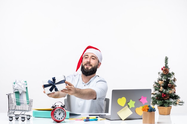 Urlaubsstimmung mit positivem jungen Erwachsenen mit Weihnachtsmannmütze arbeiten