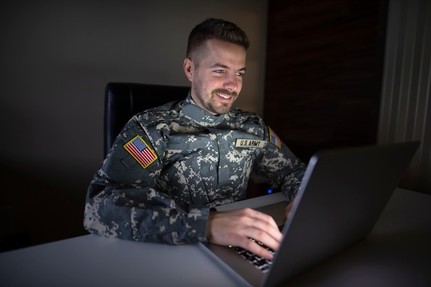 USA-Soldat in Uniform, der spät am Computer arbeitet und Post an seine Familie sendet