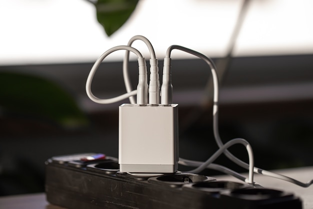 USB-Aufladung für Gadgets auf einem unscharfen Hintergrund des Raumes, Nahaufnahme. Der Begriff Technik im Alltag.