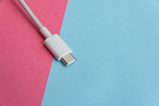 USB-Kabel Typ C über rosa und blauem Hintergrund