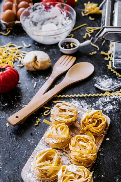 Utensilien in der Nähe von Pasta und Zutaten