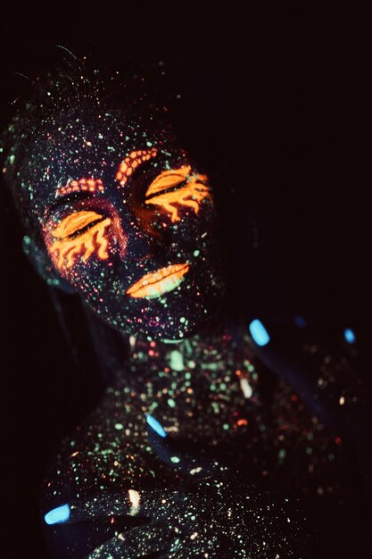 UV-Make-up. Porträt eines Mädchens in fluoreszierendem Pulver gemalt. Halloween-Konzept. Galaxie schläft.