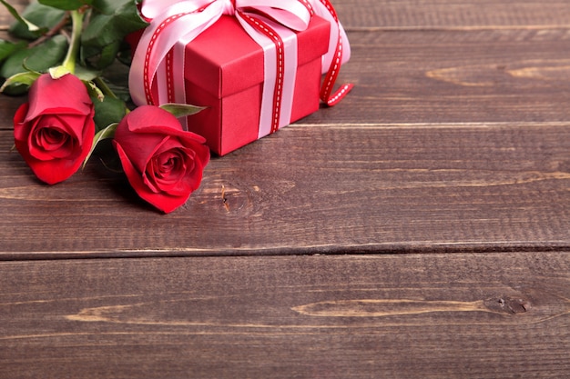 Valentine Geschenk-Box und Rosen auf Holzbrett