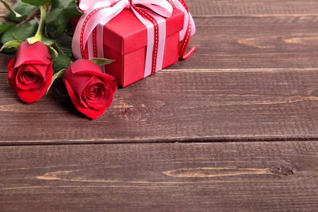 Valentine Geschenk-Box und Rosen auf Holzbrett