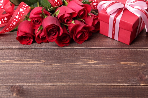 Valentine Geschenk-Box und Rosen auf Holzuntergrund