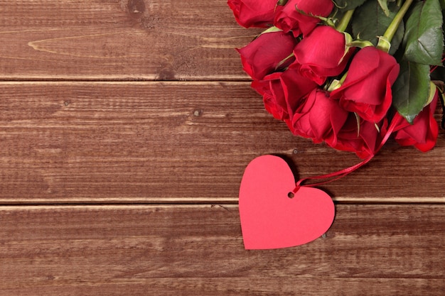 Valentine Geschenk-Tag und Rosen auf Holzbrett