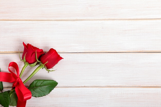 Valentine Hintergrund der roten Rosen auf weißem Holzbrett
