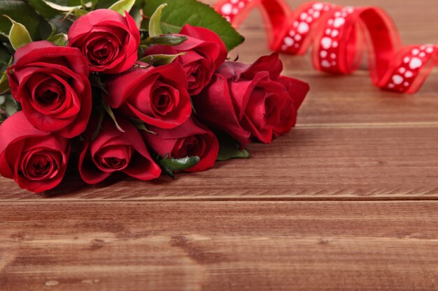 Valentine roten Rosen und Band auf einem Holzbrett